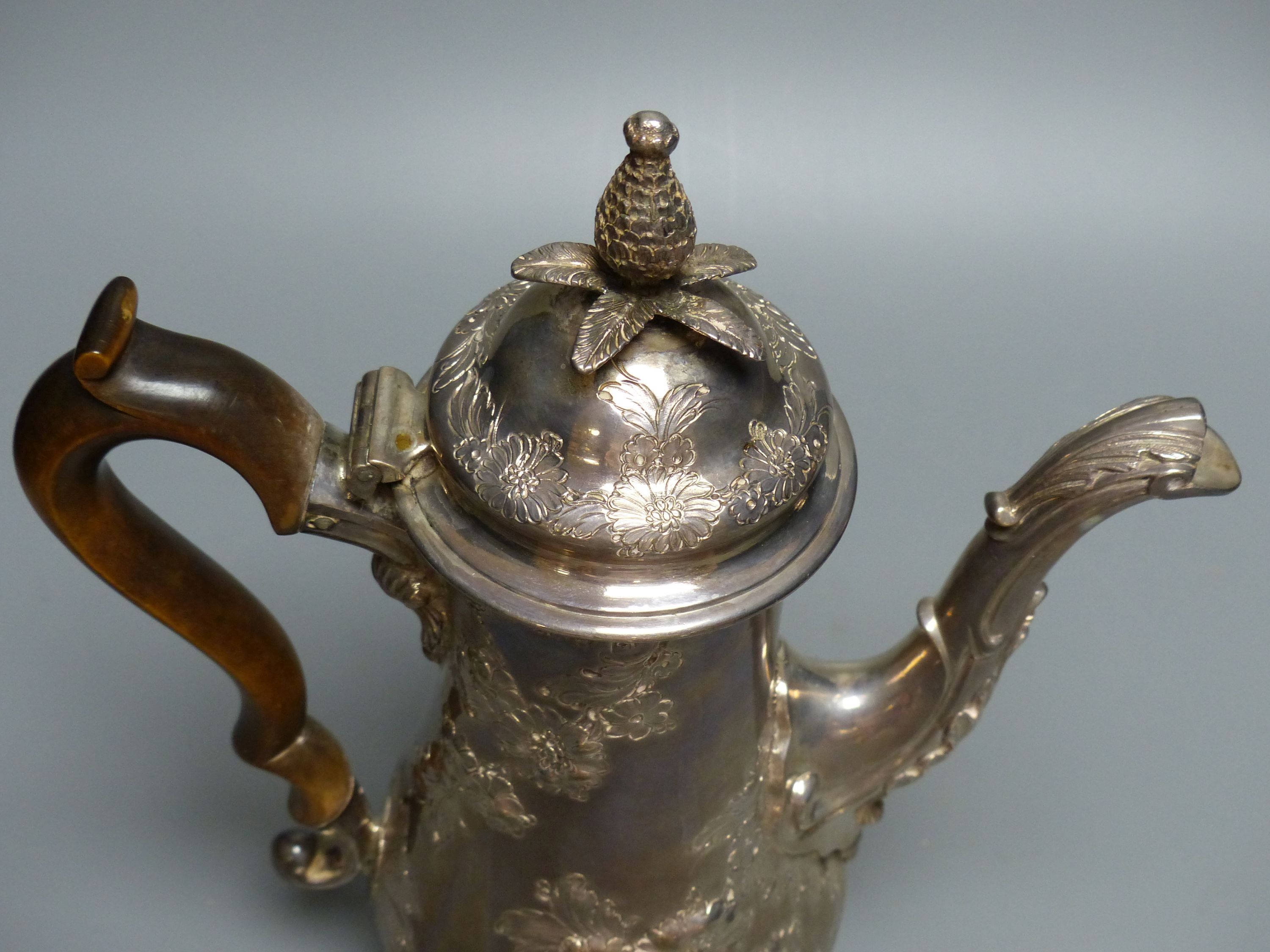 An early George III silver coffee pot, with later embossed decoration, maker ?D over WI,